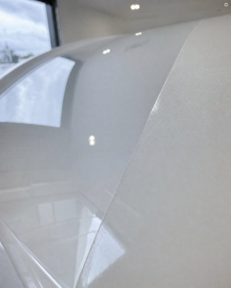 Detailing1 Ergebnis der Antihologramm Politur: schnurgerade Abklebekante auf weißem Audi-Lack