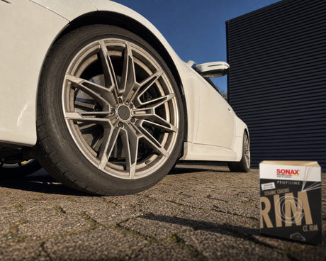 Detailing1 Bremsstaub-Film auf der Felge eines weissen BMW M2 mit SONAX PROFILINE CC Rim daneben