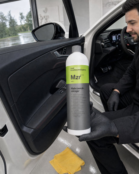 Nettoyant multi-usages Koch-Chemie Mzr dans la main de Daniel, portière ouverte de l'Audi RS 5 blanche, panneau de porte noir profond.
