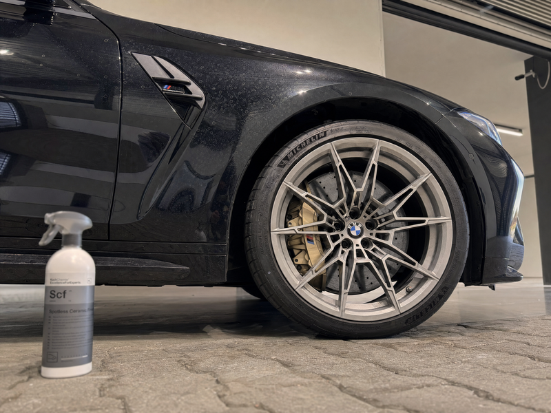 BMW M3 noire avec des taches d'eau sur le revêtement céramique, à côté de Koch-Chemie Spotless Ceramic Finish