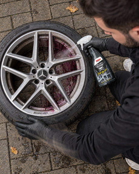 Daniel sprays SONAX FelgenBeast into the inner barrel of a removed wheel as the brake dust turns purple