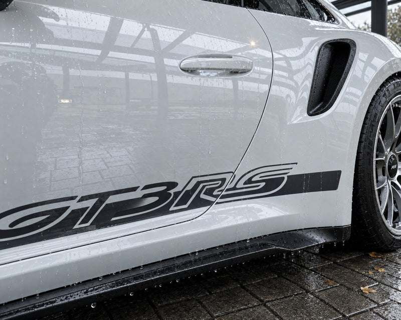 Zwei-Eimer-Methode Ergebnis: saubere, nass glänzende Tür eines weißen Porsche 911 GT3 RS nach der Handwäsche