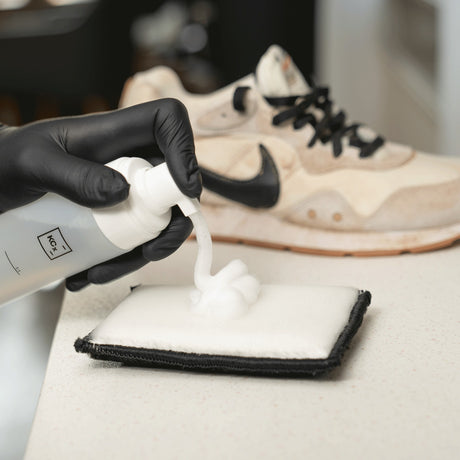 Detailing1 COLOURLOCK Sneaker Cleaner — Reinigungsschaum auf dem Pad, dahinter der verschmutzte Sneaker
